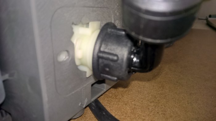 Närplansbild av diskmaskinens vattenanslutning med vickbart rör och synlig vit plastdel.