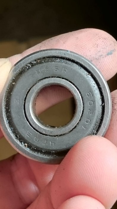 Hand håller ett kullager märkt med "USSR" som är en del av en renoverad verktygsvagn.