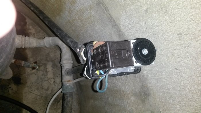 En pump med elektriska anslutningar och inställningsrattar i ett pumprum.