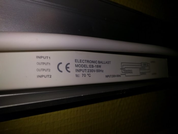 Närbild av etiketten på en elektronisk ballast för lysrör, märkt med "ELECTRONIC BALLAST" och modellinformation.