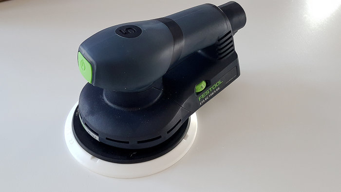 En Festool ETS 150/5 slippapper monterad på en slät yta, utan systainer-förpackning.