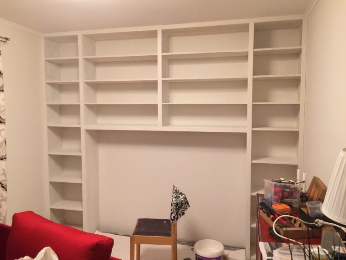 Vit, hemmabyggd bokhylla i MDF och furu med foder, ännu ej fylld med böcker.
