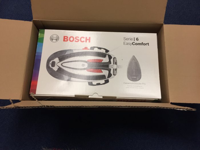 Bosch Serie | 6 EasyComfort strykjärn i kartong, oöppnad förpackning på blått mattgolv.