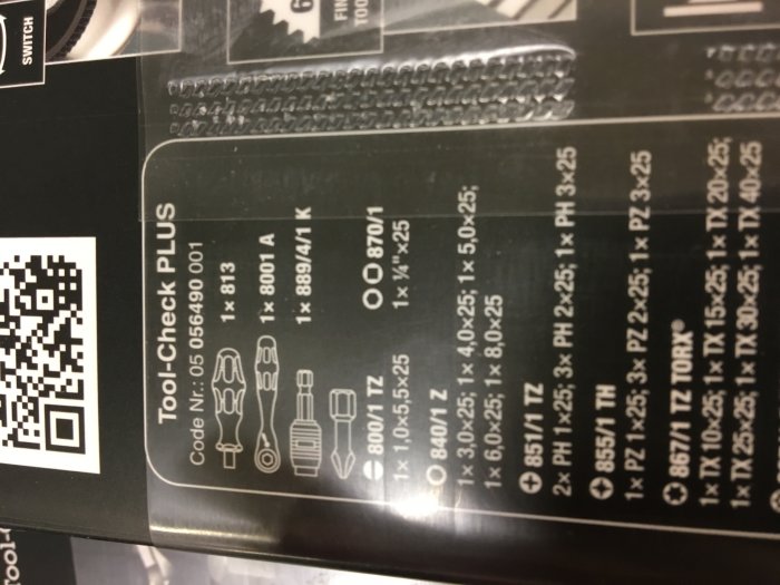 Otydlig bild på en produktförpackning med text och illustrationer av verktygsset.