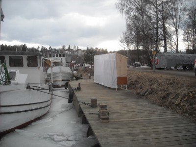 Tillfällig bryggverkstad vid en båtbrygga under vinter, med båtar och byggnadsställning.