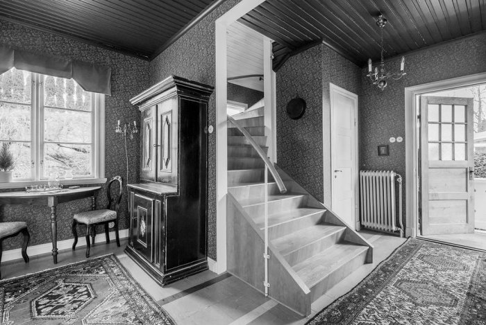 Monokromt inredningsutrymme med grå väggar, golv och övervägande grå möbler och detaljer.