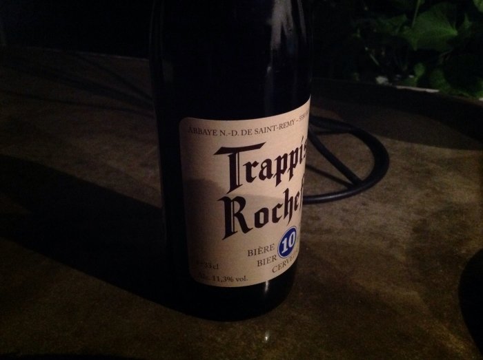 Flaska belgiskt Trappistöl "Rochefort 10" på ett mörkt bord, 11,3% volym alkohol.