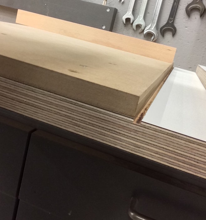 Hantverksmässig stötlåda i björkplywood med laminat, spår för spån och anhåll i verkstadsmiljö.