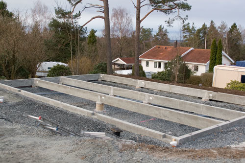 Grunden till ett hus under konstruktion med betongplintar och grus, skiss möjligen illustrerar denna uppbyggnad.