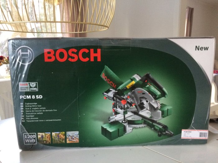 Ny förpackad Bosch PCM 8 SD kap- och geringssåg på kartongen, redo för unboxing.