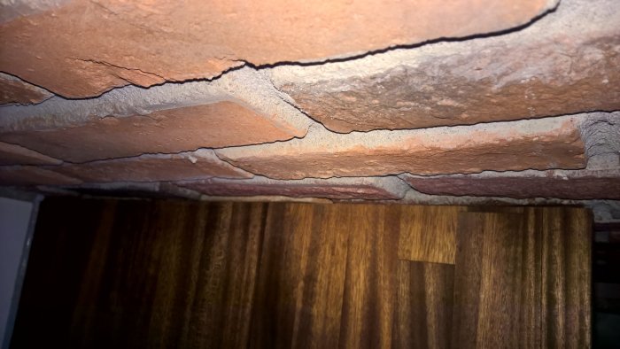 Glipa mellan ojämn tegelvägg och mörk valnötsbänkskiva, varierande bredd 3-10mm.