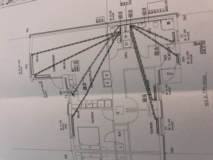 Arkitektritning av ett hus som visar rumindelning och mått, med flera markerade linjer och anteckningar.