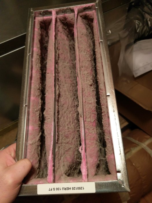 Närbild på en smutsig och dammig ventilationsfilter insats tagen under ett filterbyte.