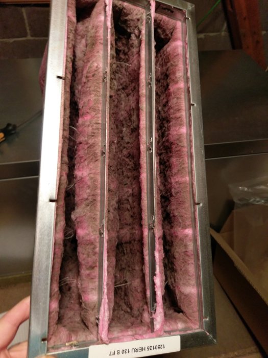 Förorenat filter i ventilationsaggregat med tydligt damm och smutsansamling, redo för byte.