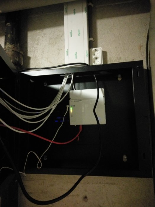 Fibernätverksinstallation i rackskåp med synliga kablar och en monterad CPE.