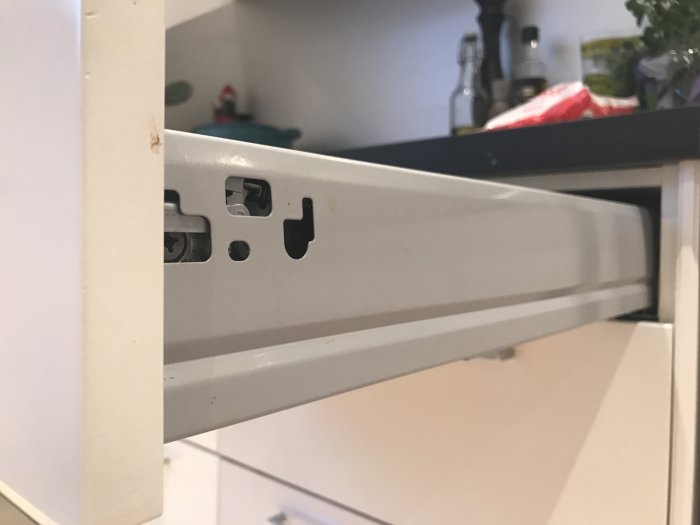 Närbild på kökslådans skena utan brickor, ofullständig montering synlig.
