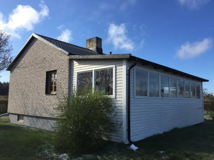 Hus på Gotland med en vitmålad altan med många fönster, påbörjat renoveringsprojekt.