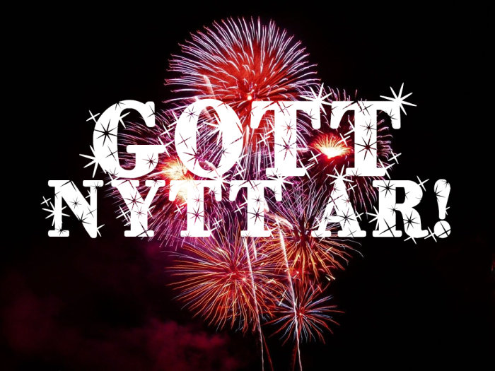 Fyrverkerier på nattsvart himmel med texten "GOTT NYTT ÅR!" i stora vita bokstäver.