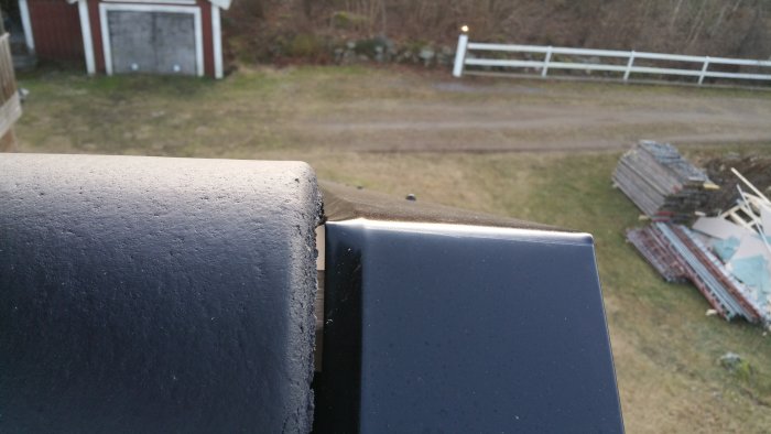 Taknock med nockpanna som ej passar under kanten på överlaggande plåtarbete, sett uppifrån.