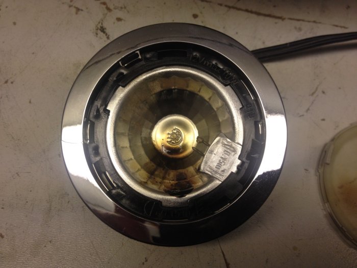 Skadad LED-lampa med smälta lödningar och tecken på överhettning i vitrinskåpsarmatur.