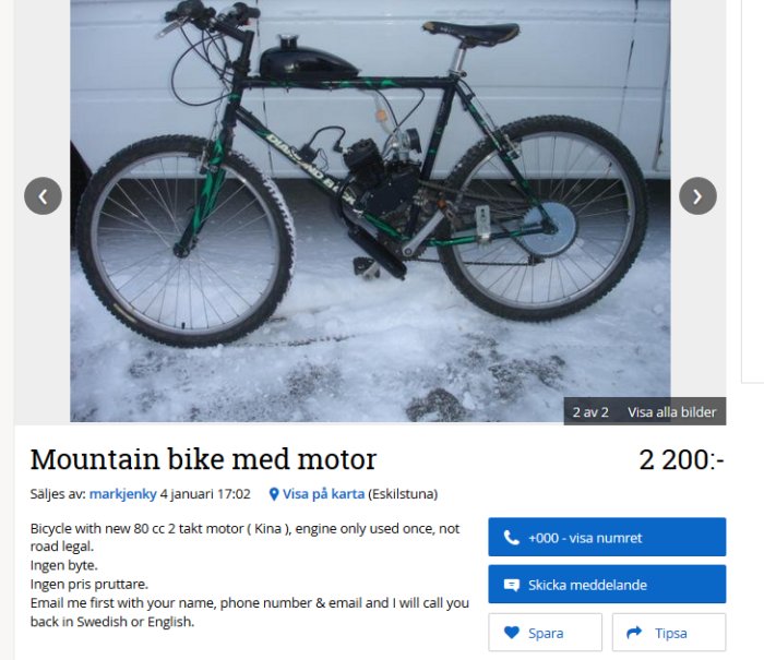 Mountainbike med motor parkerad i snön framför en vit skåpbil.