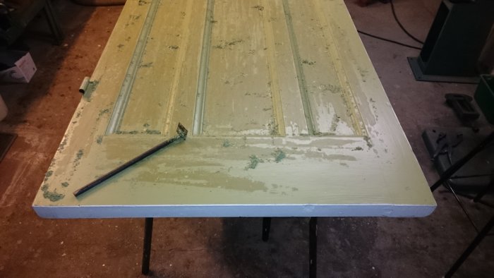 Gamla spegeldörr under renovering med skrapat grönt färglager och synlig trästruktur.
