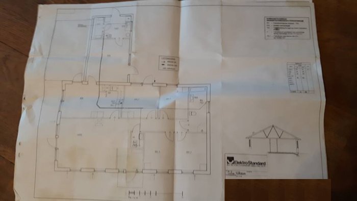 Ritning av enplansvilla med tydliga markeringar för olika rum och mått, samt en liten sektionsritning av huset.