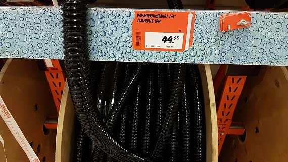 Rulle med svart dammtätningsslang i butikshylla med prisskylt.