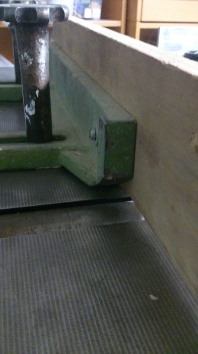 Extra anhåll av gjutjärn monterat på inmatningsbord av träbearbetningsmaskin.