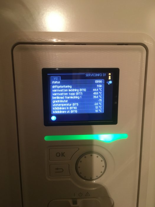 Digital termostat med temperaturinställningar och statusinformation för värme och köldbärare.