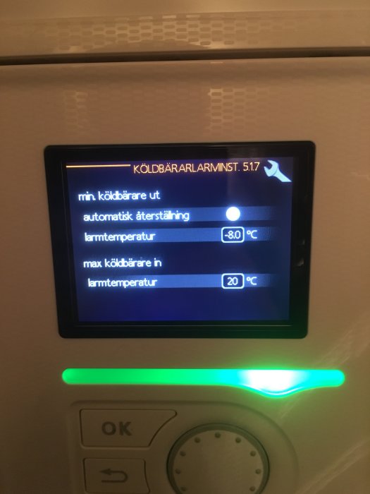 Display på värmesystem som visar ändrad larmgräns till -10 grader och automatisk återställning aktiverad.