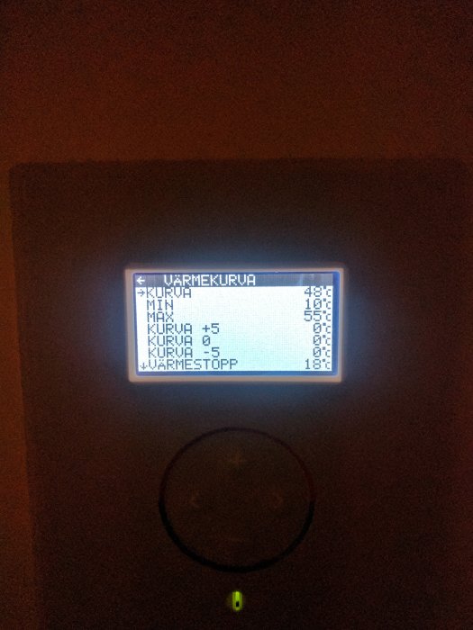 Display av en värmepumpsregulator som visar värmekurvans inställningar med text "VÄRMEKURVA" överst.