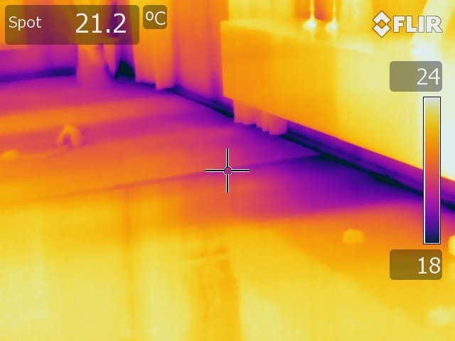 Termisk bild som visar temperaturskillnader i ett rum, indikerande isoleringsbrister i bjälklaget.