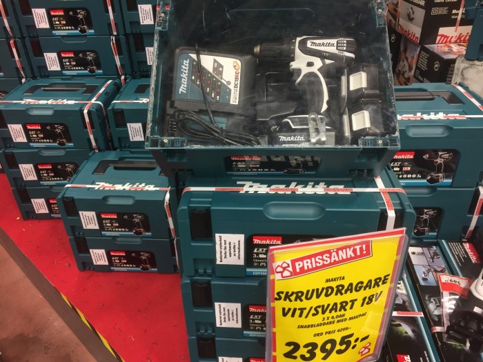 Makita skruvdragare i butik med prisskylt, flera förpackade verktyg och batterier i bakgrunden.