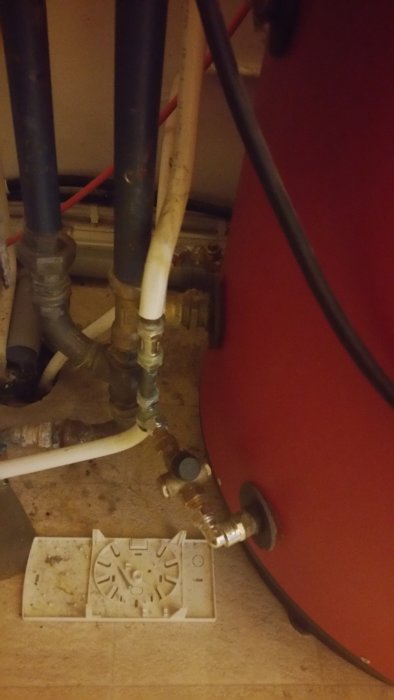 Röd Wamsler panna med rörkopplingar och en värmefördelare i förgrunden.