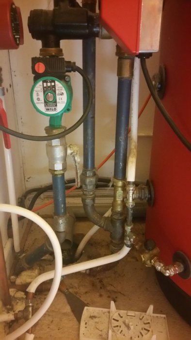 VVS-installation med rör, pump och del av en Wamsler-enhet i ett tekniskt utrymme.