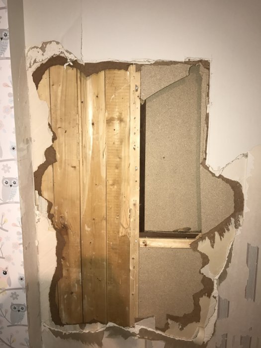 En delvis avtäckt väggvisande råspont och reglar efter borttaget gips inför köksrenovering.