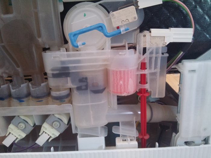 Renoverad och återmonterad mekanik inuti en hushållsmaskin, visande rena och organiserade komponenter.