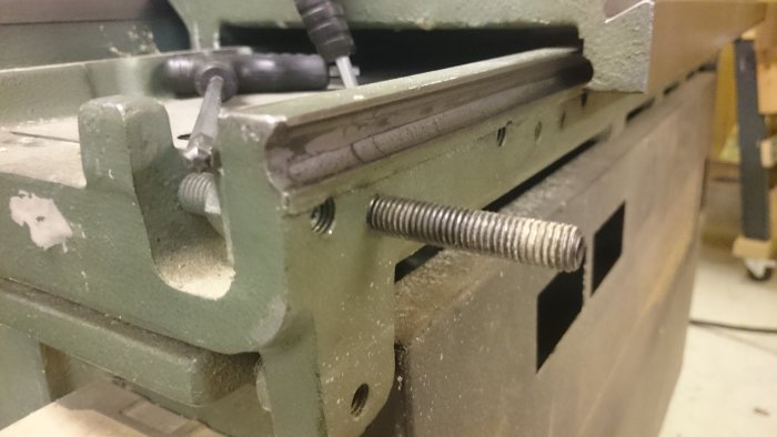 Närbild av slitna utfrästa banor i gjutjärnsjusterbordet på en Felder BF5-41 kombimaskin.