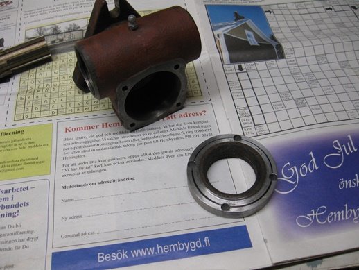 Mekaniska komponenter på tidningspapper, inklusive ett kullager och snäckväxelhus.