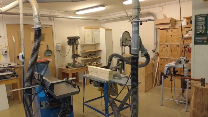 Verkstadslokaler med träbearbetningsmaskiner och virke för en hyvelbänk.