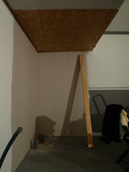 Renoveringsprojekt visar osminkat hörn med nyinstallerade lister, målad salning och delvis färdigt tak.