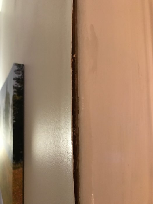 Tapetskärv som lossnat och böjt sig från väggen vid en hörna.