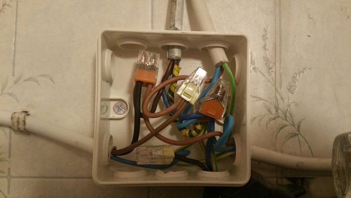 Öppen elektrisk kopplingsdosa med flera ihopkopplade kablar och RJ45-kontakter, ordentligt fixerad efter renovering.
