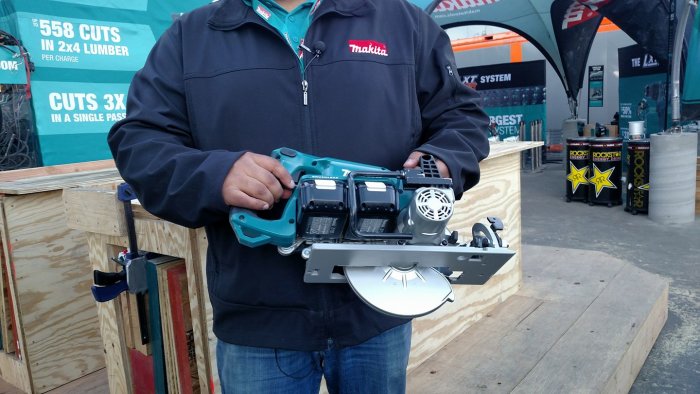 Person håller en Makita worm drive cirkelsåg på en hantverkarmässa.