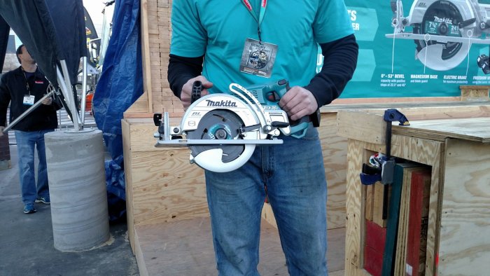 Person håller en Makita cirkelsåg vid en hantverkarmässa.
