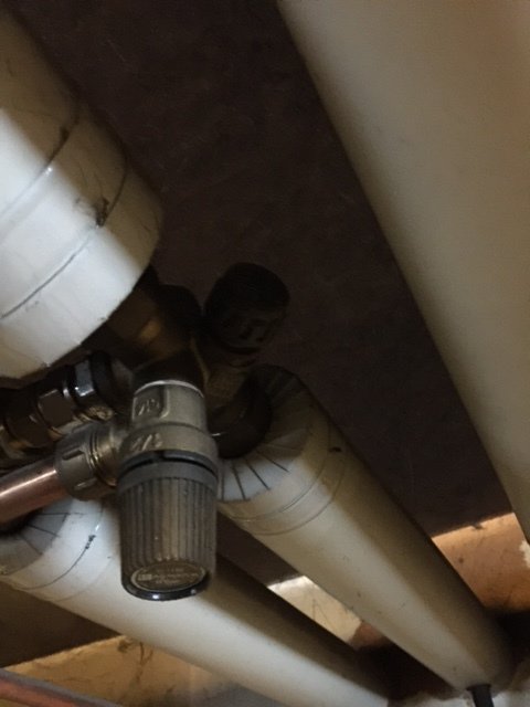 Installationsbild av ett partikelfilter med avluftare i ett pannrum, anslutet till rörledningar.