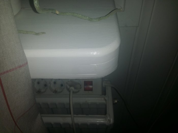 Nybyggd vit fönsterbänk med ojämnheter och en växt, ovanför ett element och eluttag.