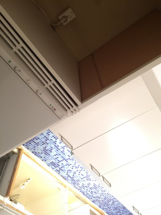 Köksskåp och elluttag ovanför en möjlig plats för installation av diskmaskin.