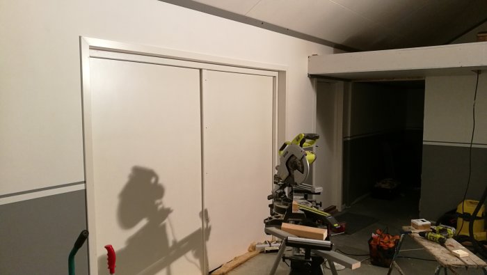 Nyinstallerade tak och vägglister runt garderobsdörrar i ett pågående renoveringsprojekt.